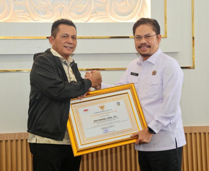 
					Gubernur Kepulauan Riau Ansar Ahmad menyerahkan piagam penghargaan kepada Nurus Solichin, Kepala BPN Kepri yang kini menjabat amanah baru sebagai Kepala BPN Riau. Piagam diserahkan dalam silaturahmi digelar di Ruang VIP Bandara RHF Tanjungpinang, Senin (14/9/20260. 