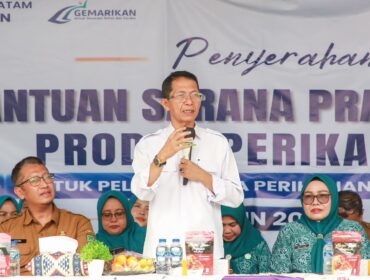 Wali Kota Batam, Amsakar Achmad, didampingi Ketua TP-PKK Batam, Erlita Amsakar, dan Kepala Dinas Perikanan Kota Batam, Yudi Atmajianto, menyampaikan sambutan saat penyerahan bantuan sarana dan prasarana kepada kelompok pengolah dan pemasaran hasil perikanan di Sagulung, Senin (14/9/2026). 