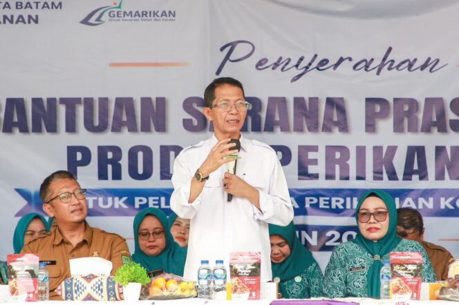 
					Wali Kota Batam, Amsakar Achmad, didampingi Ketua TP-PKK Batam, Erlita Amsakar, dan Kepala Dinas Perikanan Kota Batam, Yudi Atmajianto, menyampaikan sambutan saat penyerahan bantuan sarana dan prasarana kepada kelompok pengolah dan pemasaran hasil perikanan di Sagulung, Senin (14/9/2026). 