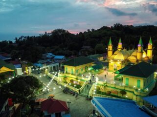 Komplek Balai Adat Pulau Penyengat di waktu malam dengan latar belakang Kota Tanjungpinang di waktu malam