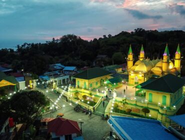 Komplek Balai Adat Pulau Penyengat di waktu malam dengan latar belakang Kota Tanjungpinang di waktu malam